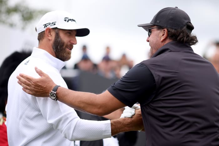 ST ALBANS, ENGLAND - JUNE 09: Dustin Johnson of 4 Aces GC greets Phil Mickelson of Hy Flyers GC during day one of the LIV Golf Invitational - London at The Centurion Club on June 09, 2022 in St Albans, England. (Photo by Charlie Crowhurst/LIV Golf/Getty Images)