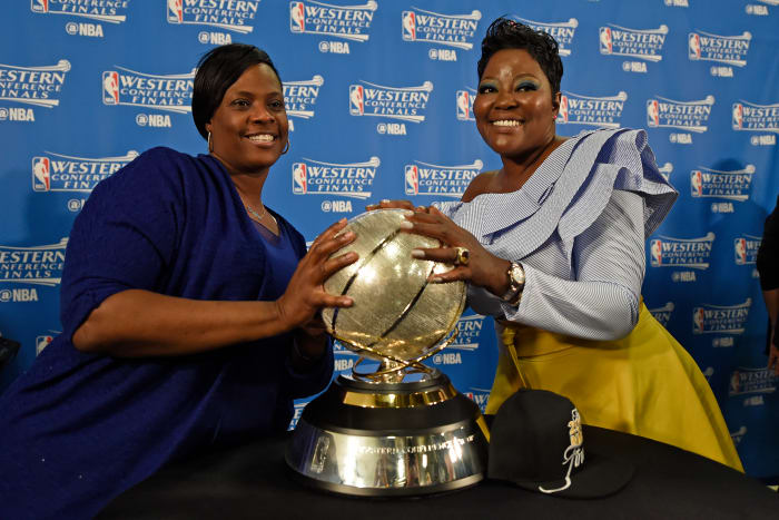 Draymond Green and Kevin Durant's moms holding the trophy following an NBA game.