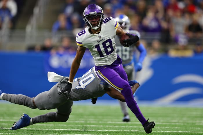 Justin Jefferson runs through a tackle by a Detroit Lions defender.