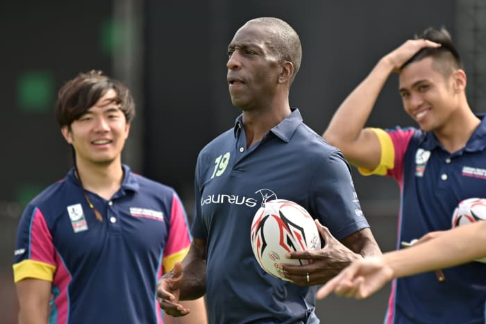 In this photo taken on April 3, 2019, retired US athlete and Olympic gold medalist Michael Johnson (C) attends a promotional event ahead of the Hong Kong Rugby Sevens tournament. - US sprint champion Michael Johnson says he is "back to normal" after he was blindsided by his stroke last year, in a recovery he credits in part to his rewarding years of charity work. Johnson is in Hong Kong for the weekend's Rugby Sevens tournament -- the biggest event on the city's sporting calendar. (Photo by Anthony WALLACE / AFP) / TO GO WITH AFP STORY RUGBY-HKG-ATHLETICS-USA-JOHNSON,INTERVIEW BY SEAN GLEESON (Photo credit should read ANTHONY WALLACE/AFP via Getty Images)