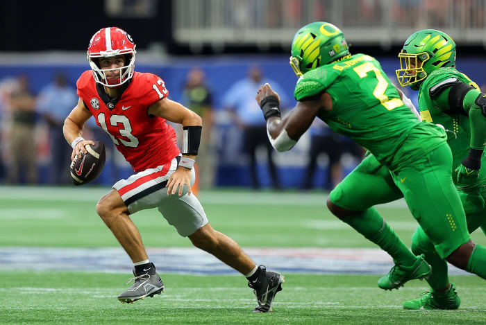 ATLANTA, GEORGIA - SEPTEMBER 03: Stetson Bennett #13 of the Georgia Bulldogs escapes the pocket away from DJ Johnson #2 and Keyon Ware-Hudson #95 of the Oregon Ducks in the first quarter of the Chick-fil-A Kick-Off Game at Mercedes-Benz Stadium on September 03, 2022 in Atlanta, Georgia. (Photo by Kevin C. Cox/Getty Images)