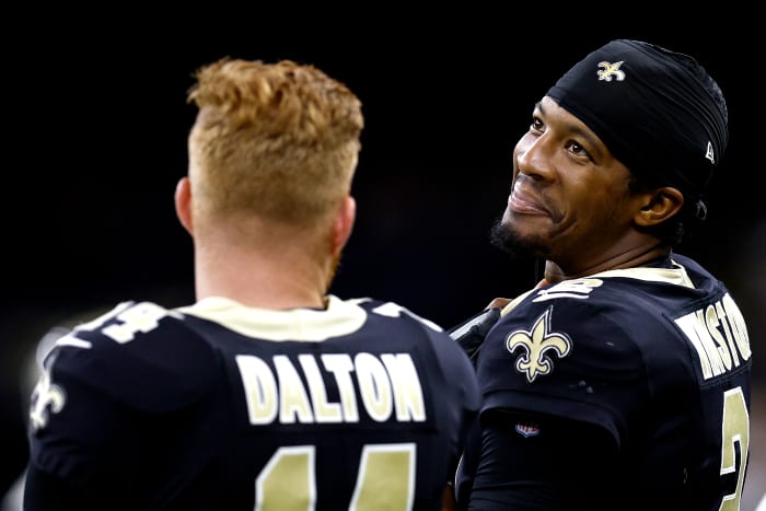 NEW ORLEANS, LOUISIANA - AUGUST 26: Jameis Winston #2 of the New Orleans Saints (R) and Andy Dalton #14 stand on the sideline during the second quarter of an NFL preseason game against the Los Angeles Chargers at Caesars Superdome on August 26, 2022 in New Orleans, Louisiana.  (Photo by Sean Gardner/Getty Images)