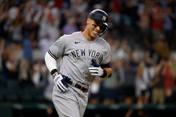 ARLINGTON, TX - OCTOBER 4: Aaron Judge #99 of the New York Yankees smiles as he rounds the bases after hitting his 62nd home run of the season against the Texas Rangers during the first inning in game two of a double header at Globe Life Field on October 4, 2022 in Arlington, Texas.  Judge has now set the American League record for home runs in a single season.  (Photo by Ron Jenkins/Getty Images)