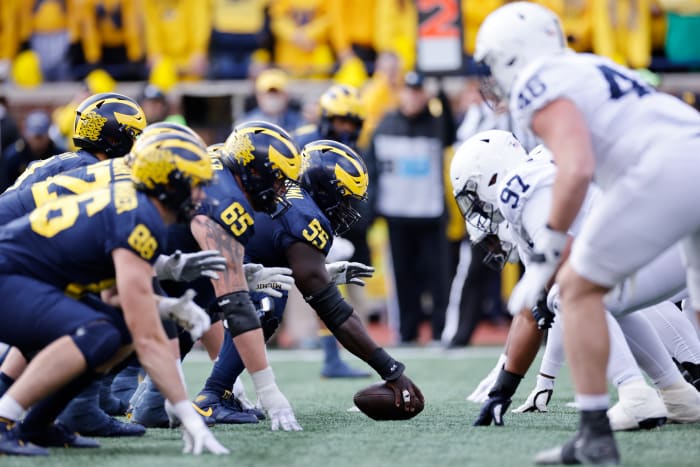 Michigan and Penn State players at the line of scrimmage.