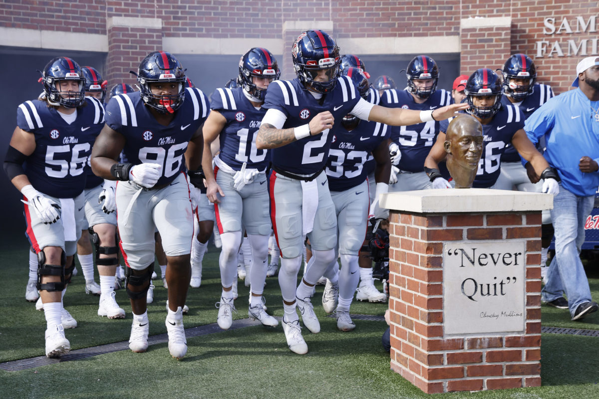 Quarterback Matt Corral leads Ole Miss out onto the field for a college football game against Liberty.