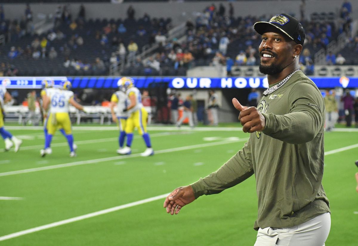 Von Miller walks down the sidelines in street clothes before a Rams game.