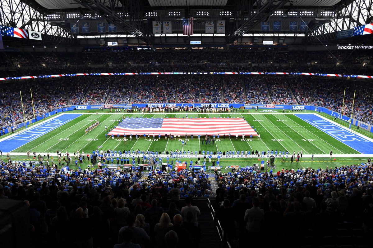 An American flag is held on the field at a Detroit Lions game.