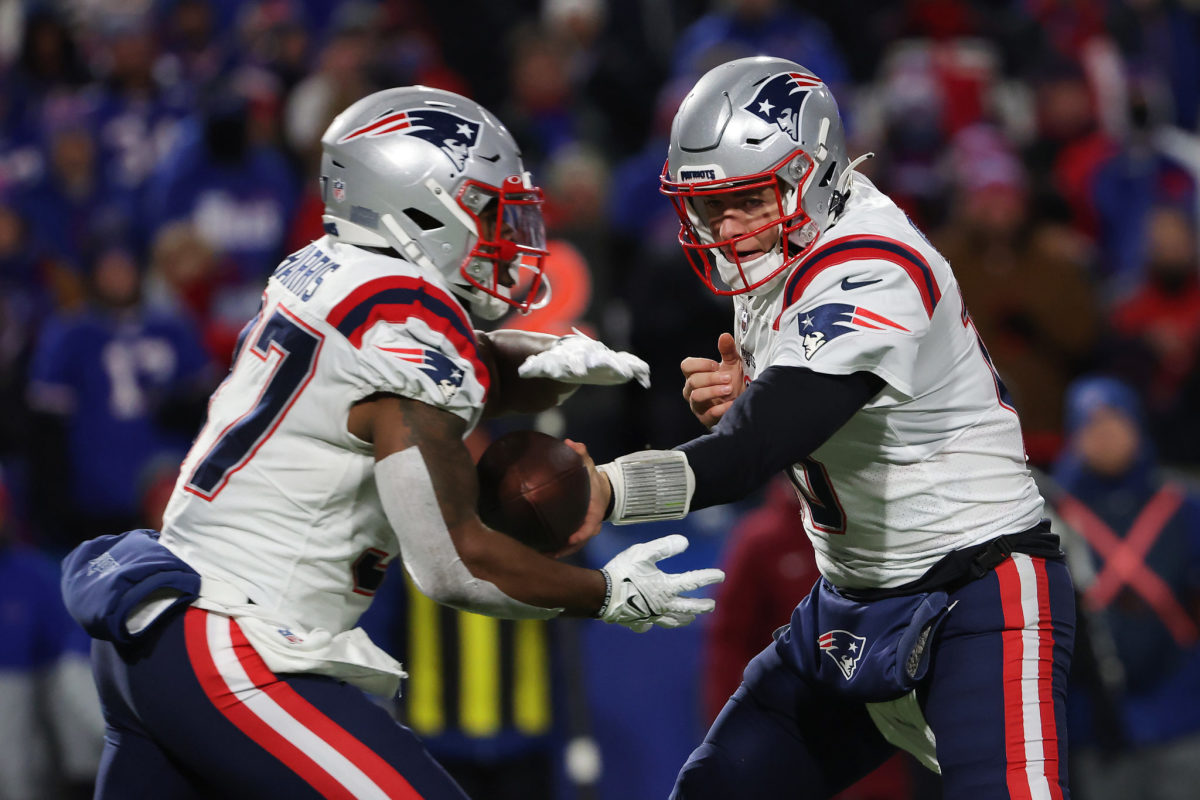 New England Patriots quarterback Mac Jones hands the ball off to running back Damien Harris.