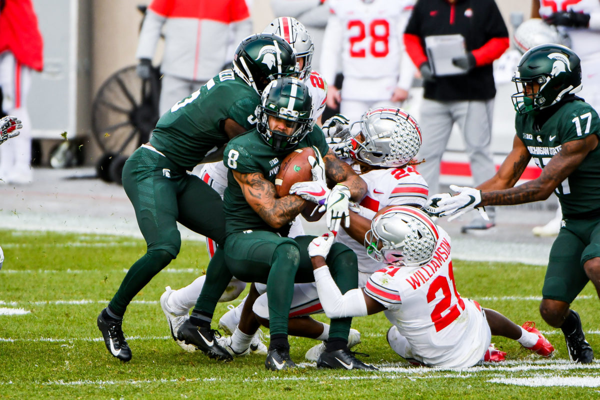 Ohio State players try too bring down Michigan State wide receiver Jalen Nailor.