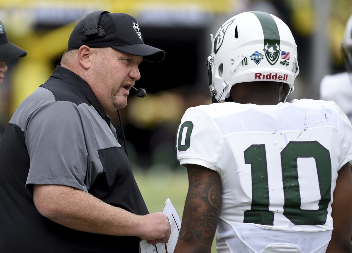 Portland State head coach Bruce Barnum talks to a player on the sideline.