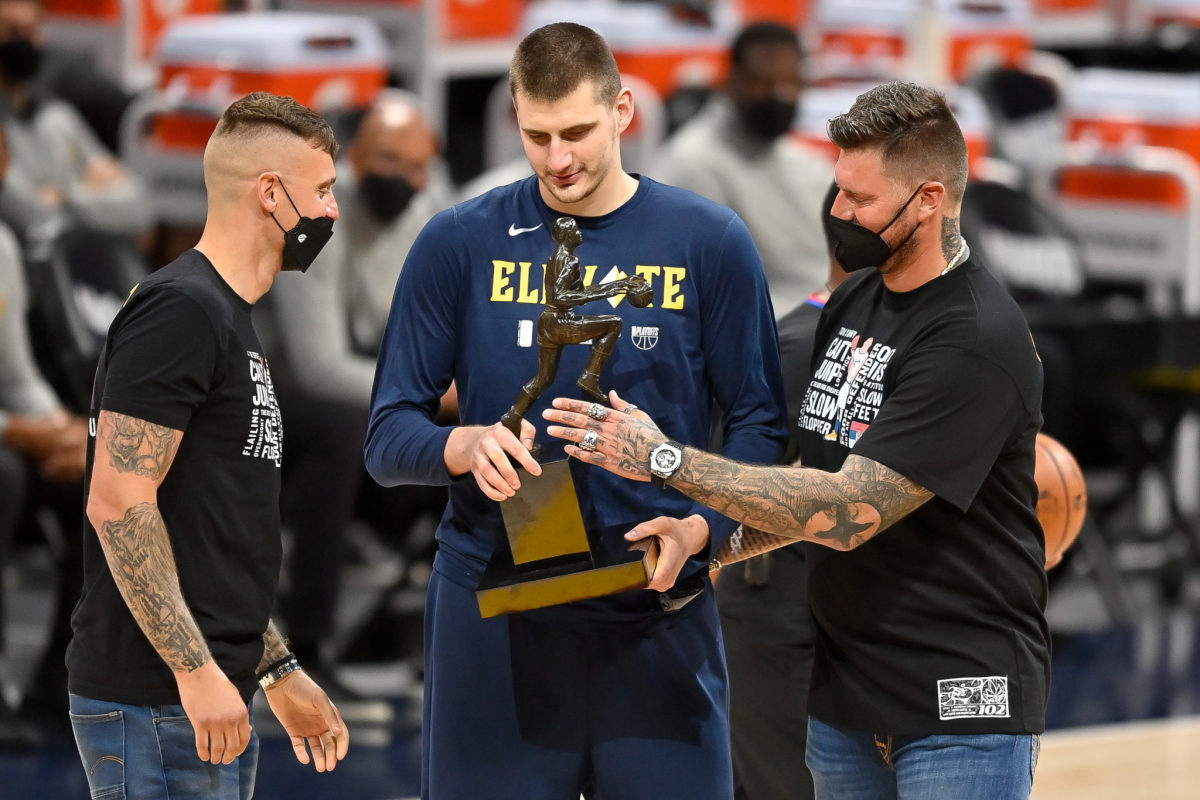 Nikola Jokic accepts the NBA MVP award alongside his two brothers.