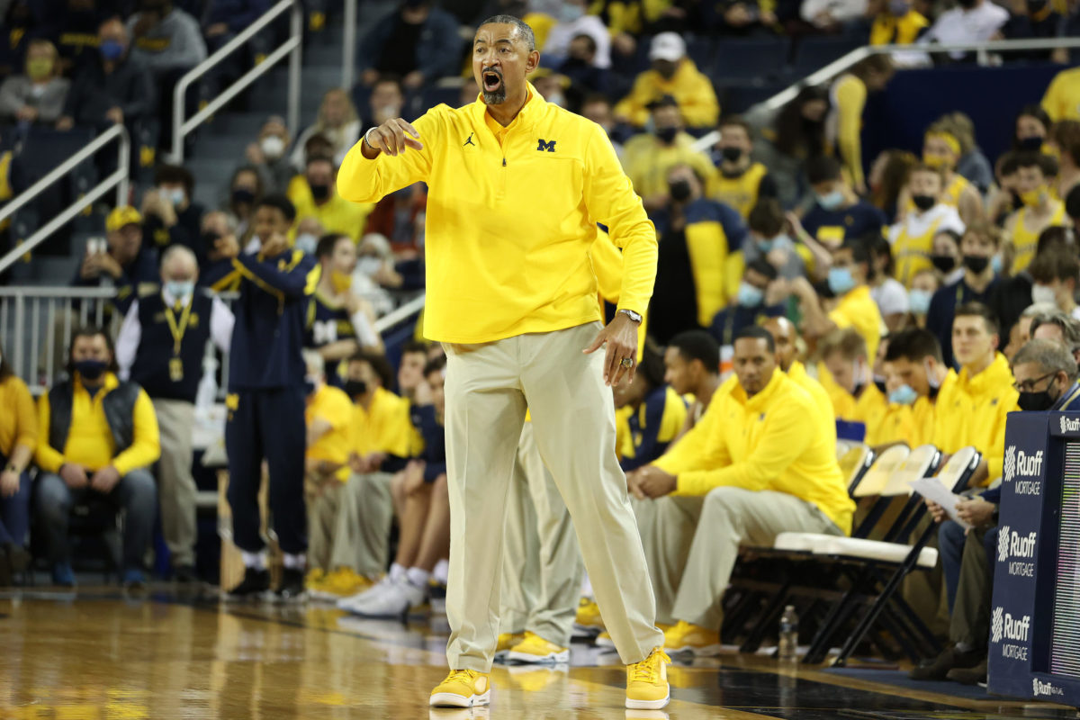 Juwan Howard coaching on the sidelines during a Michigan basketball game.