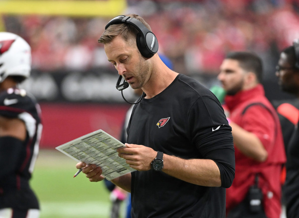 Cardinals head coach Kliff Kingsbury reads his play sheet on the sidelines during a game.