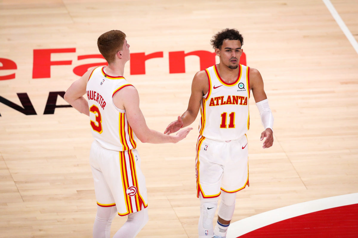 Trae Young high fives Kevin Huerter during a Hawks game.