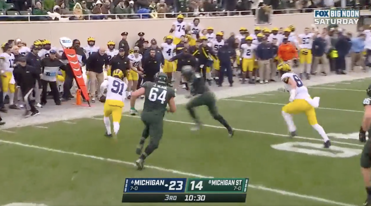 Michigan's punter runs a fake to try and pick up a first down during the 2021 FOX college football broadcast.