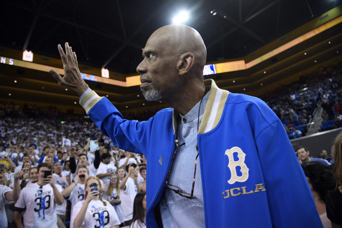 Kareem Abdul-Jabbar waves to fans as he arrive to attend the UCLA Bruins and Arizona Wildcats college basketball game.