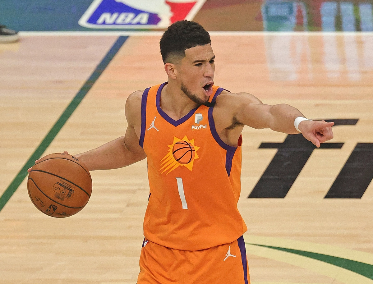 Devin Booker pointing with his left hand to direct his teammates.