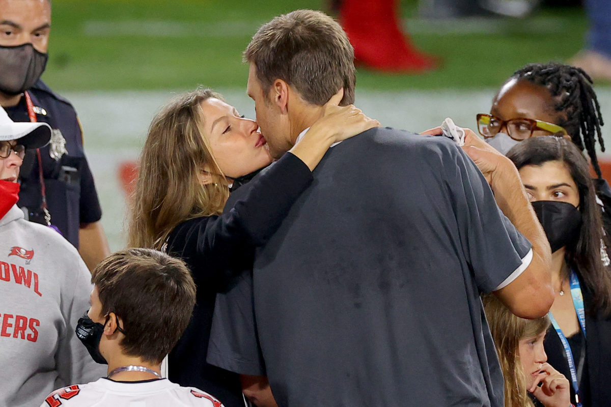 Gisele celebrates with Tom Brady on the field