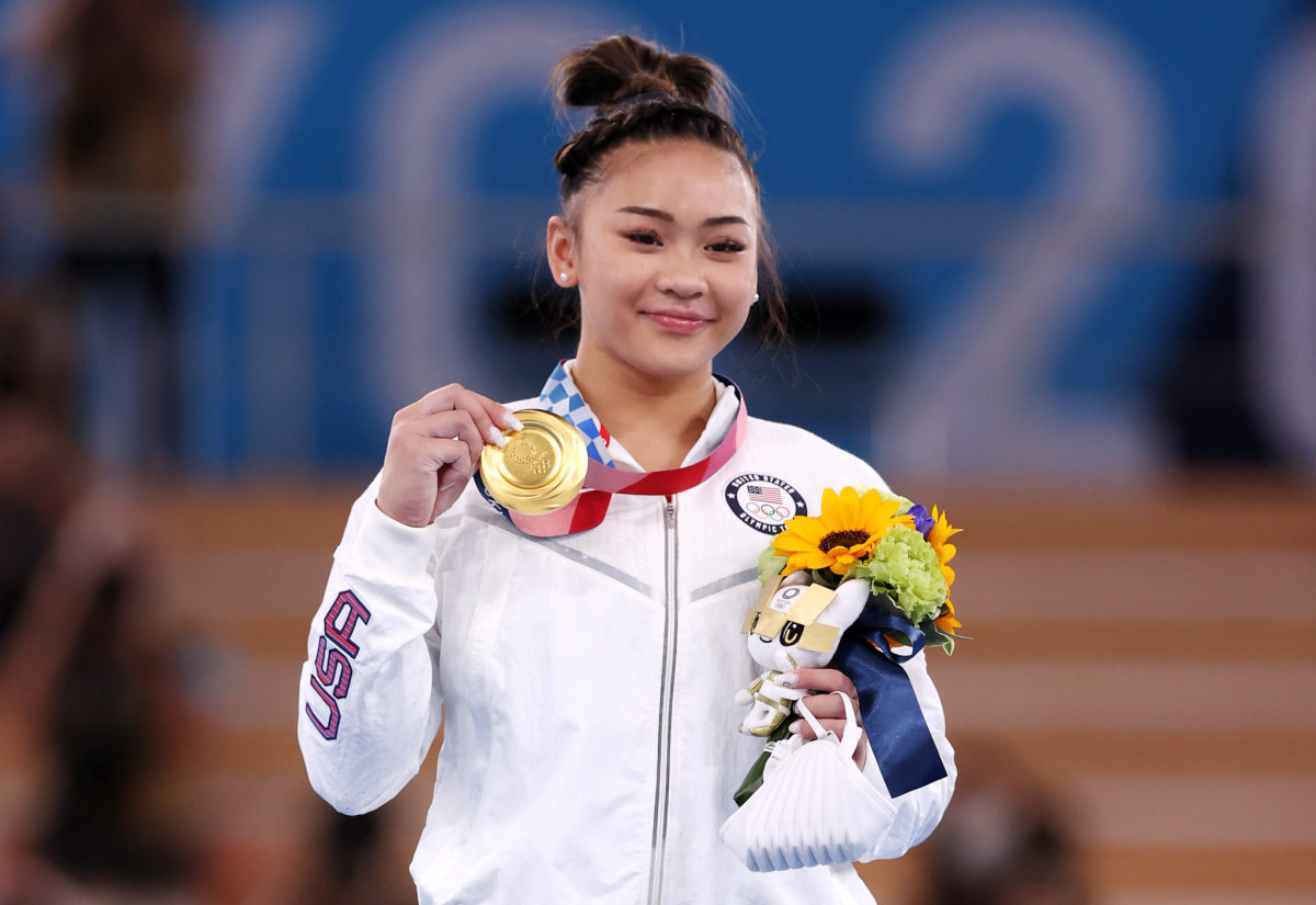 Suni Lee shows off her gold medal in the individual all-around.