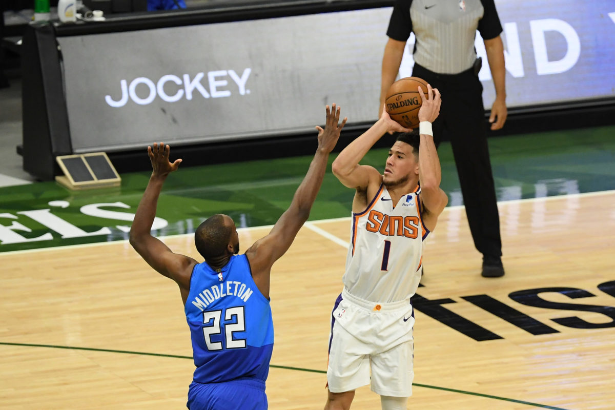 Devin Booker of the Phoenix Suns shoots a jumper over Khris Middleton of the Milwaukee Bucks.