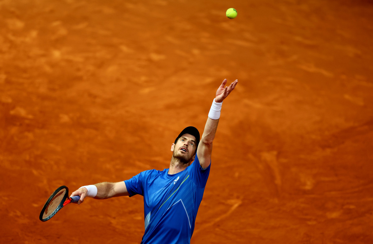 Tennis star Andy Murray in the French Open, going for a serve on the court.