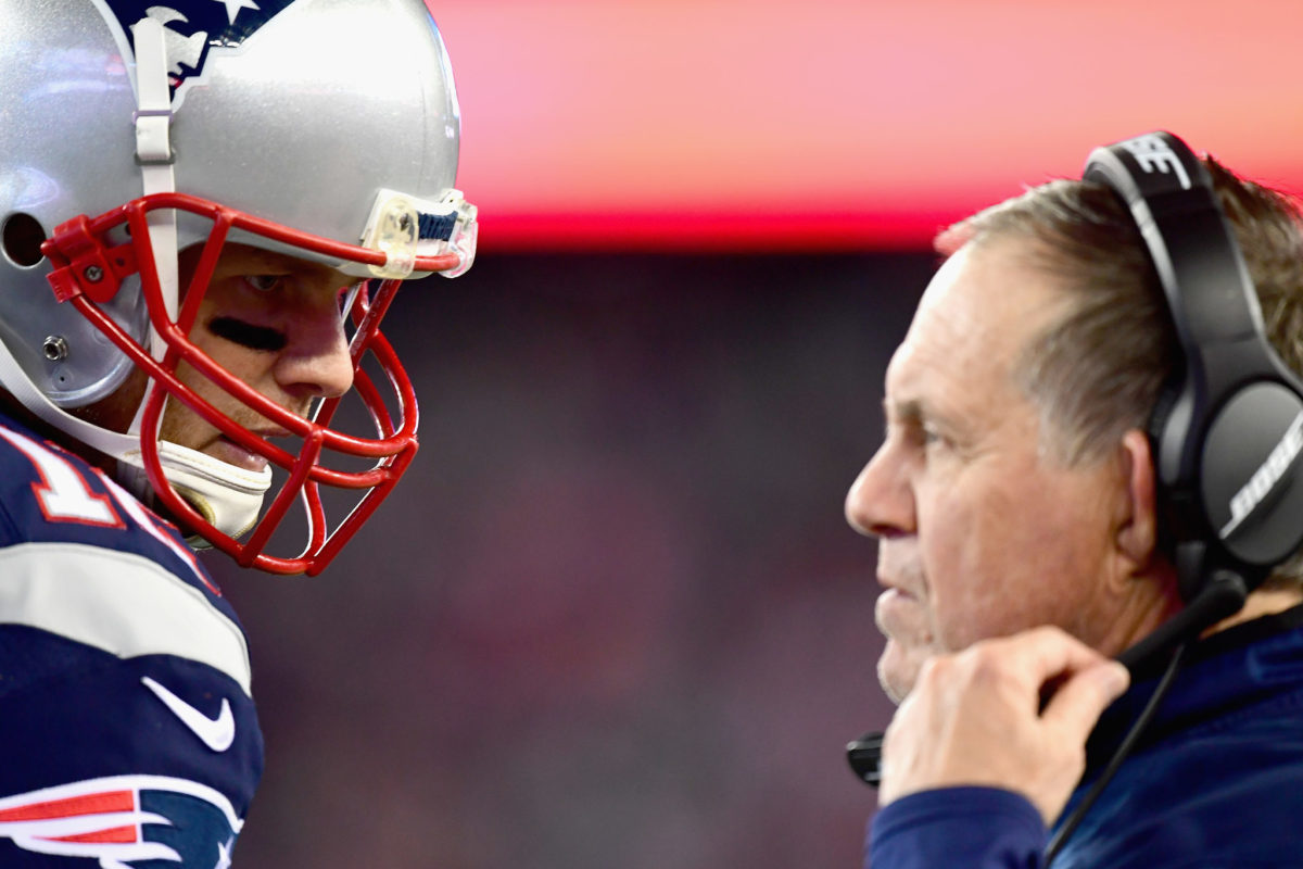 Tom Brady and Bill Belichick stand face-to-face.