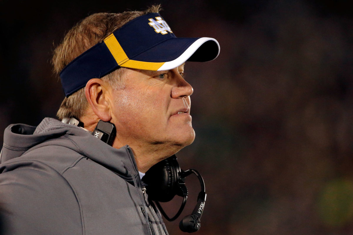 A closeup of Notre Dame football coach Brian Kelly wearing a visor.