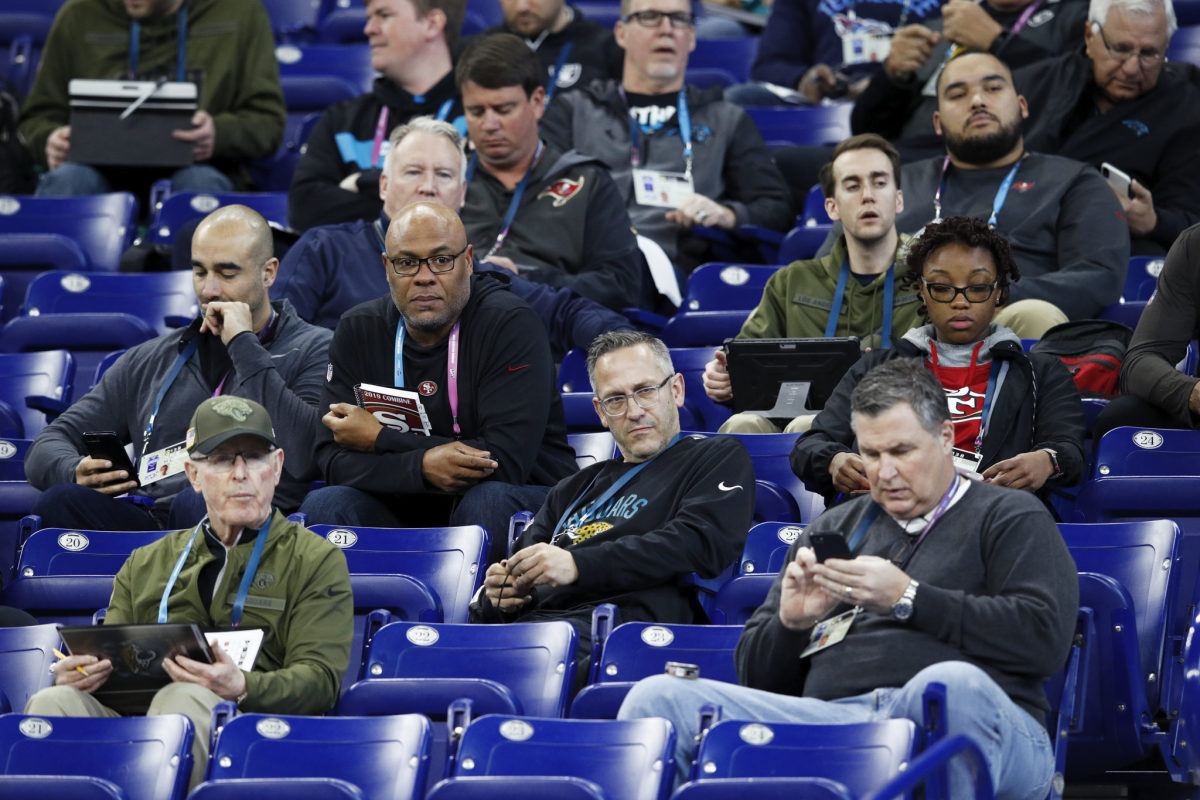 a group of nfl coaches and scouts at the nfl combine