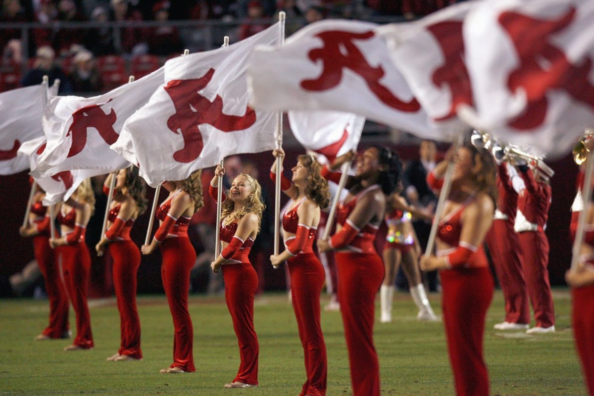 The flag girls of the Alabama Crimson Tide marching band perform before the game against the Mississippi State Bulldogs at Bryant-Denny Stadium.