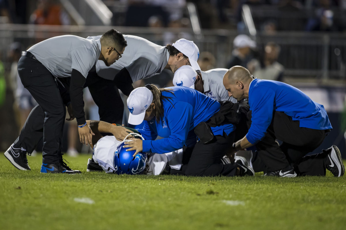 Medical staff treats Buffalo punter Evan Finegan after brutal injury.