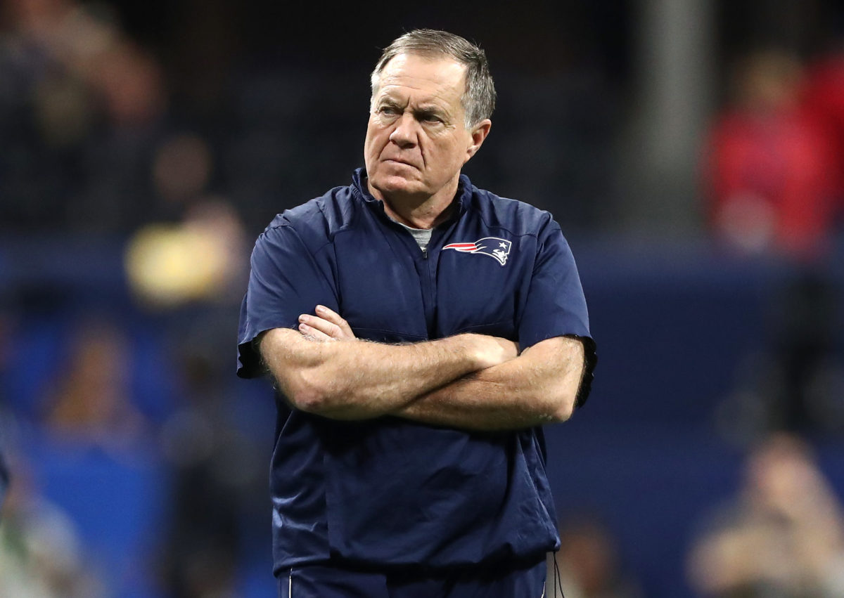 A closeup of New England Patriots coach Bill Belichick crossing his arms during a game.