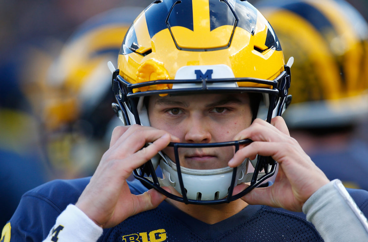 John O'Korn of the Michigan Wolverines puts his helmet on prior to the start of the Michigan football spring game.