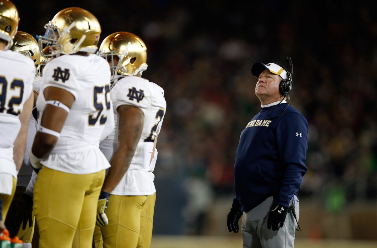 Brian Kelly looking into Notre Dame's huddle