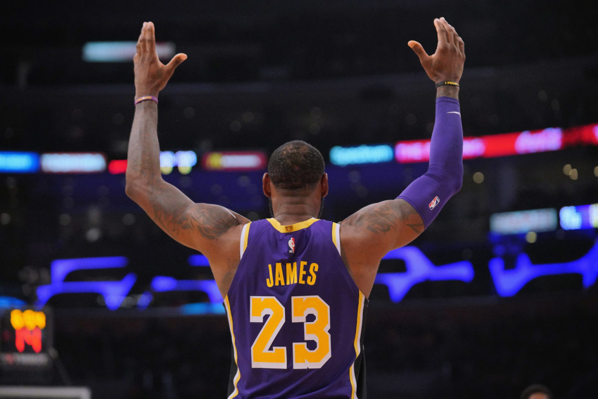Los Angeles Lakers forward LeBron James holding his arms in the air during a game.