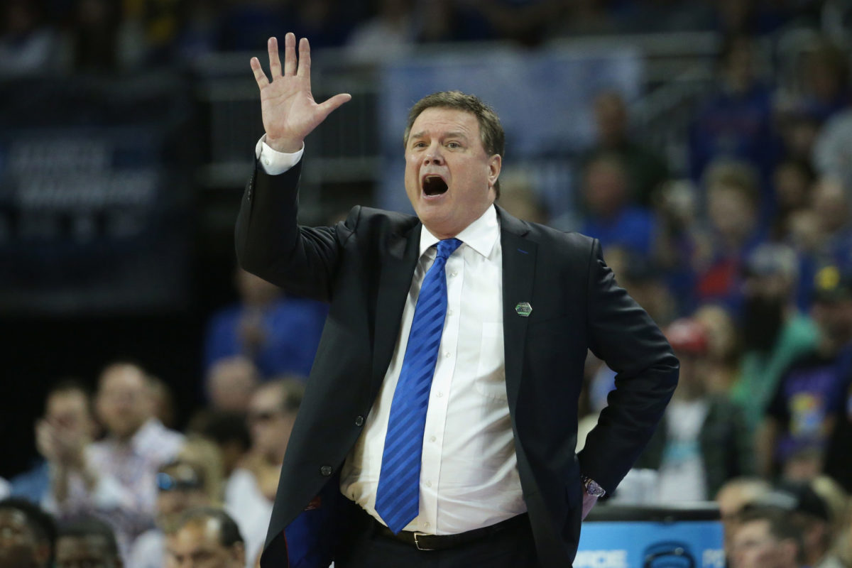 Bill Self yelling with his right hand in the air.