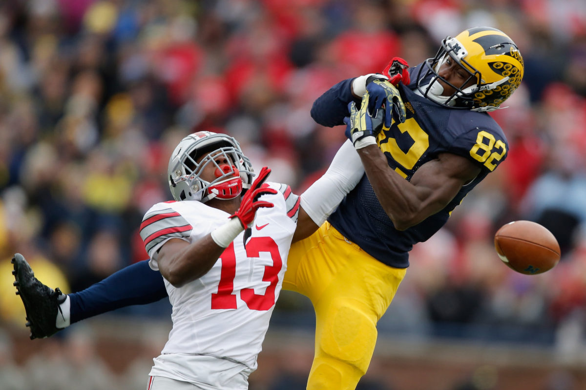An Ohio State football player deflecting a Michigan pass during a college football rivalry game.
