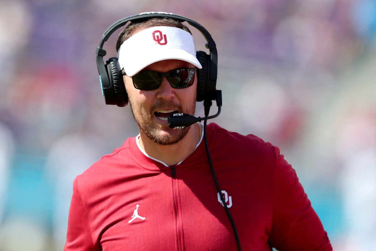A closeup of Oklahoma Sooners coach Lincoln Riley speaking into his headset.