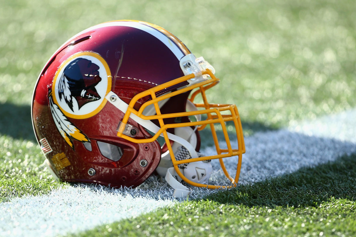 A Washington Redskins helmet sitting on the field.