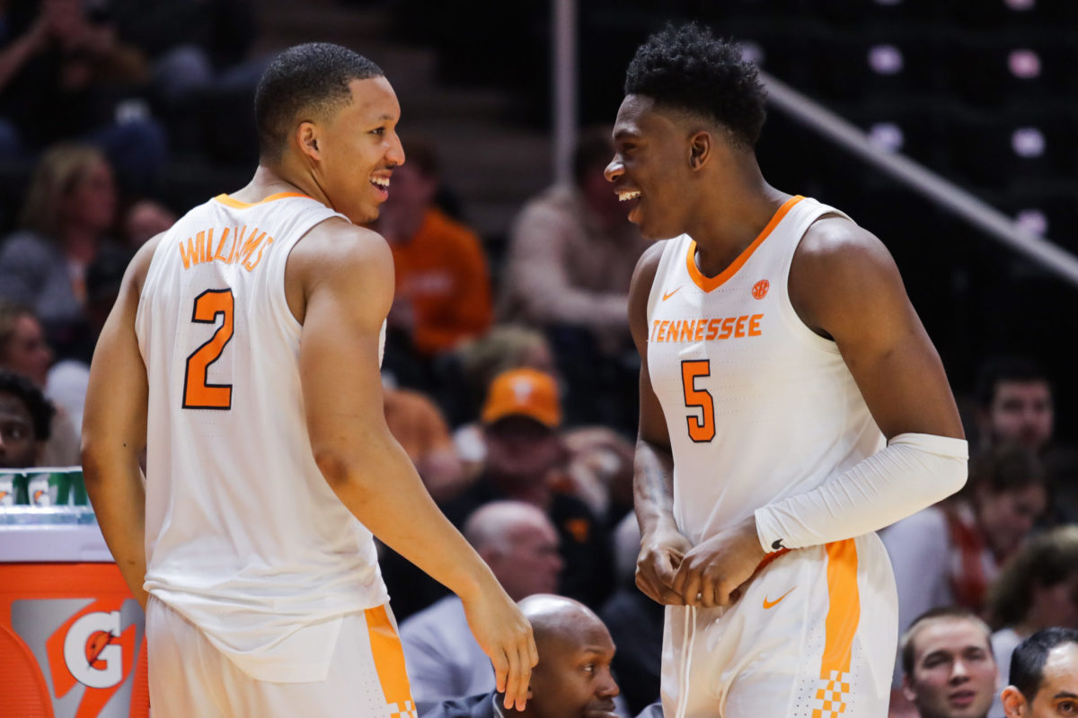 Two Tennessee basketball players smiling on the court.