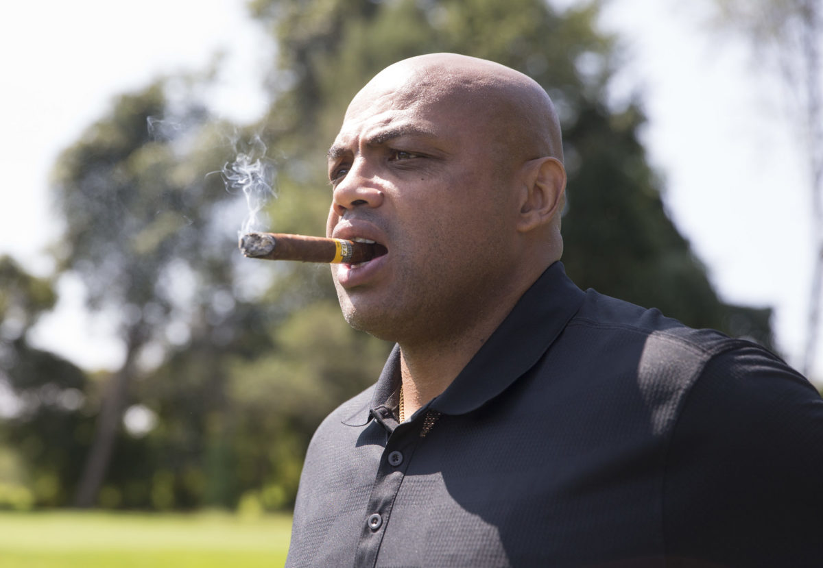 Charles Barkley smokes a cigar.