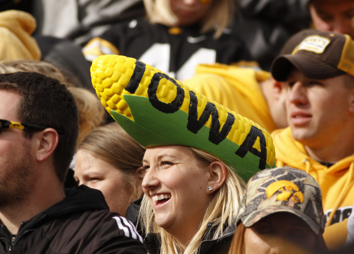 An Iowa fan wearing a corn shaped hat at a football game.
