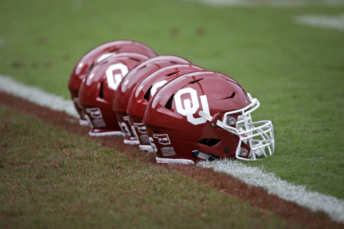 Oklahoma Sooners helmets lined up on the football field before a football game.
