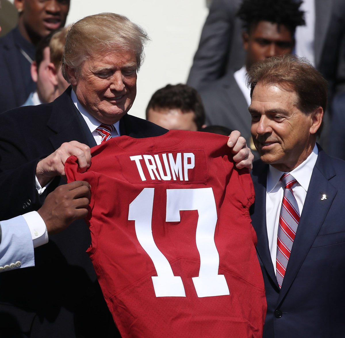 U.S. President Donald Trump stands with coach Nick Saban (R), while presented with a team jersey while honoring the 2017 NCAA Football National Champion Alabama Crimson Tide.