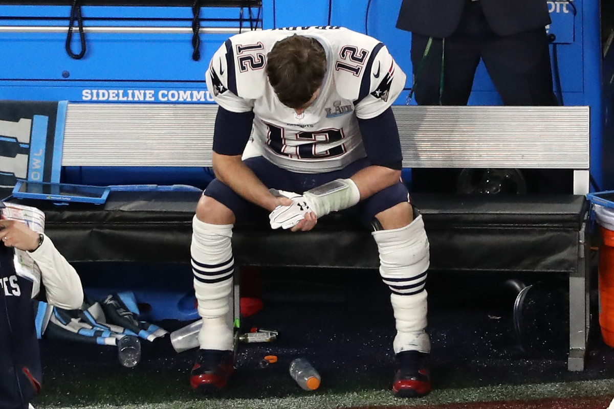 Tom Brady with his head down on the sideline.