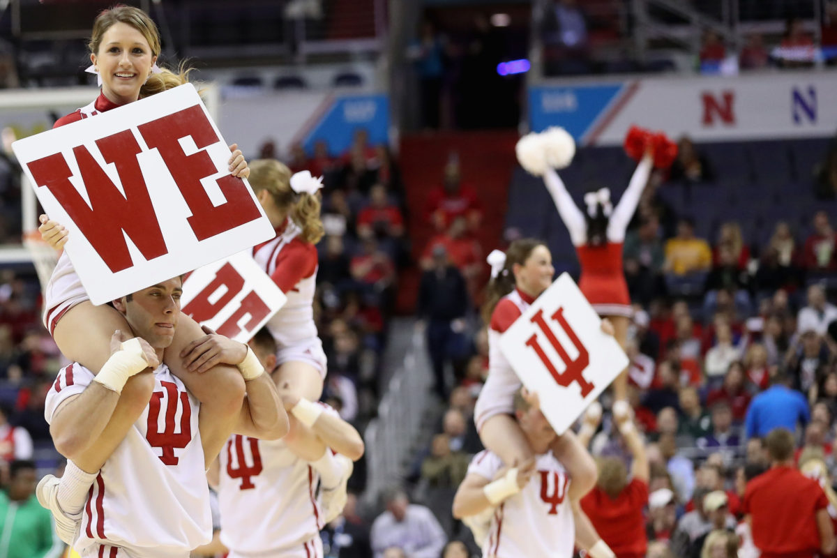 Indiana cheerleaders holding signs during a basketball game.