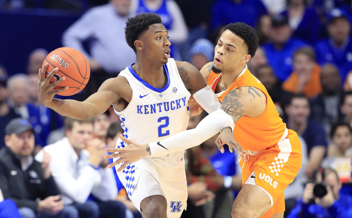 Ashton Hagans passes the ball around a Tennessee player.