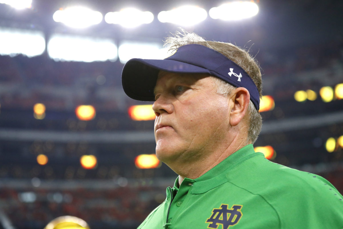 A closeup of Notre Dame head coach Brian Kelly wearing a visor.