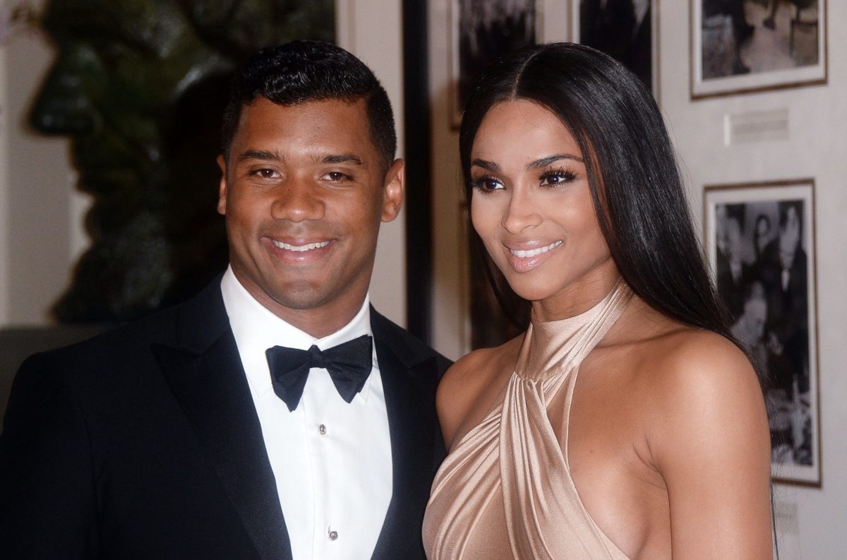 Russell Wilson posing for a photo with Ciara.
