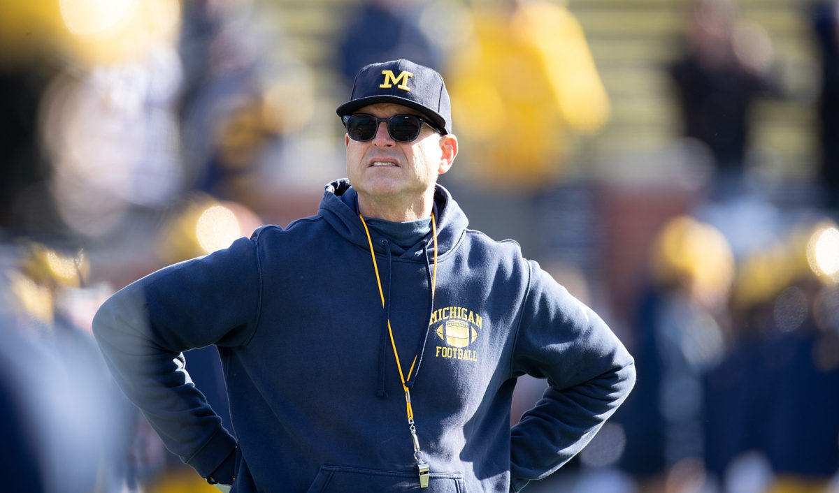 Michigan head coach Jim Harbaugh on the sideline against Michigan State in a Big Ten football rivalry game