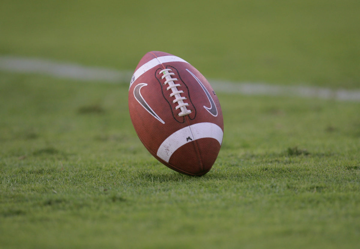 A closeup of a Nike football on the field during a game.